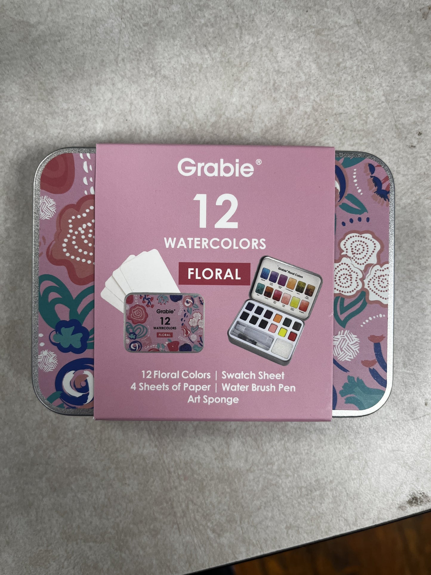 Packaging of Grabie 12 Watercolors Floral set on a gray surface