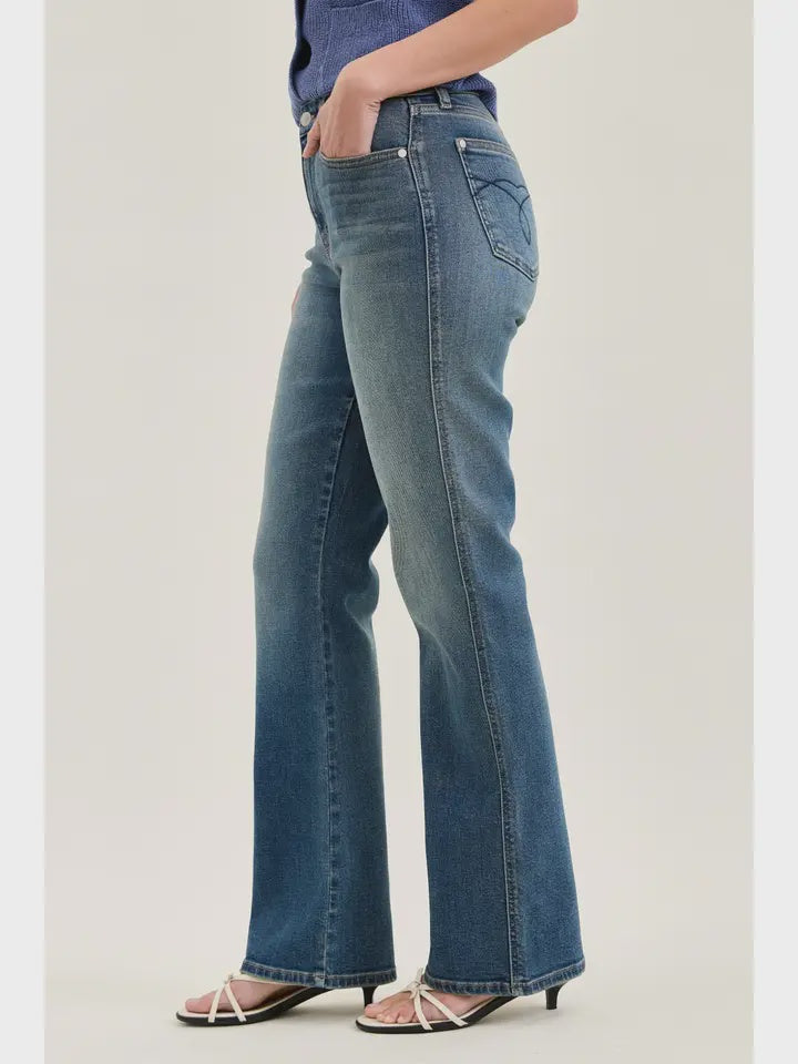 Person wearing blue jeans on a plain background