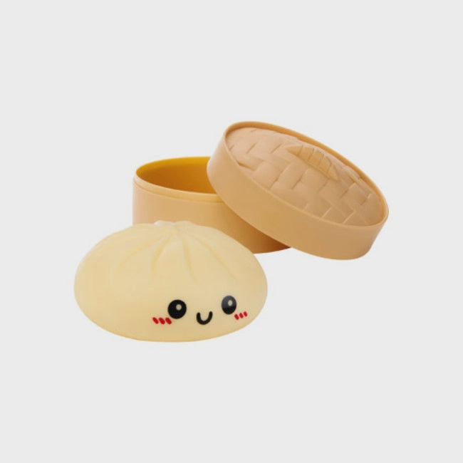 Squishy toy shaped like a dim sum bun with a smiling face on a white background
