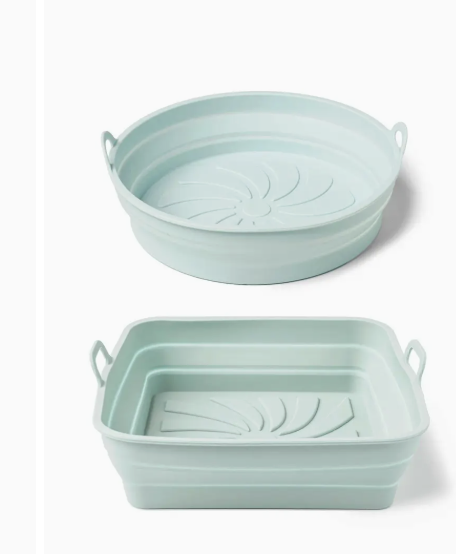 Two collapsible silicone bowls in light green on a white background