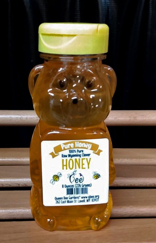 Honey bear bottle with a label on a wooden surface