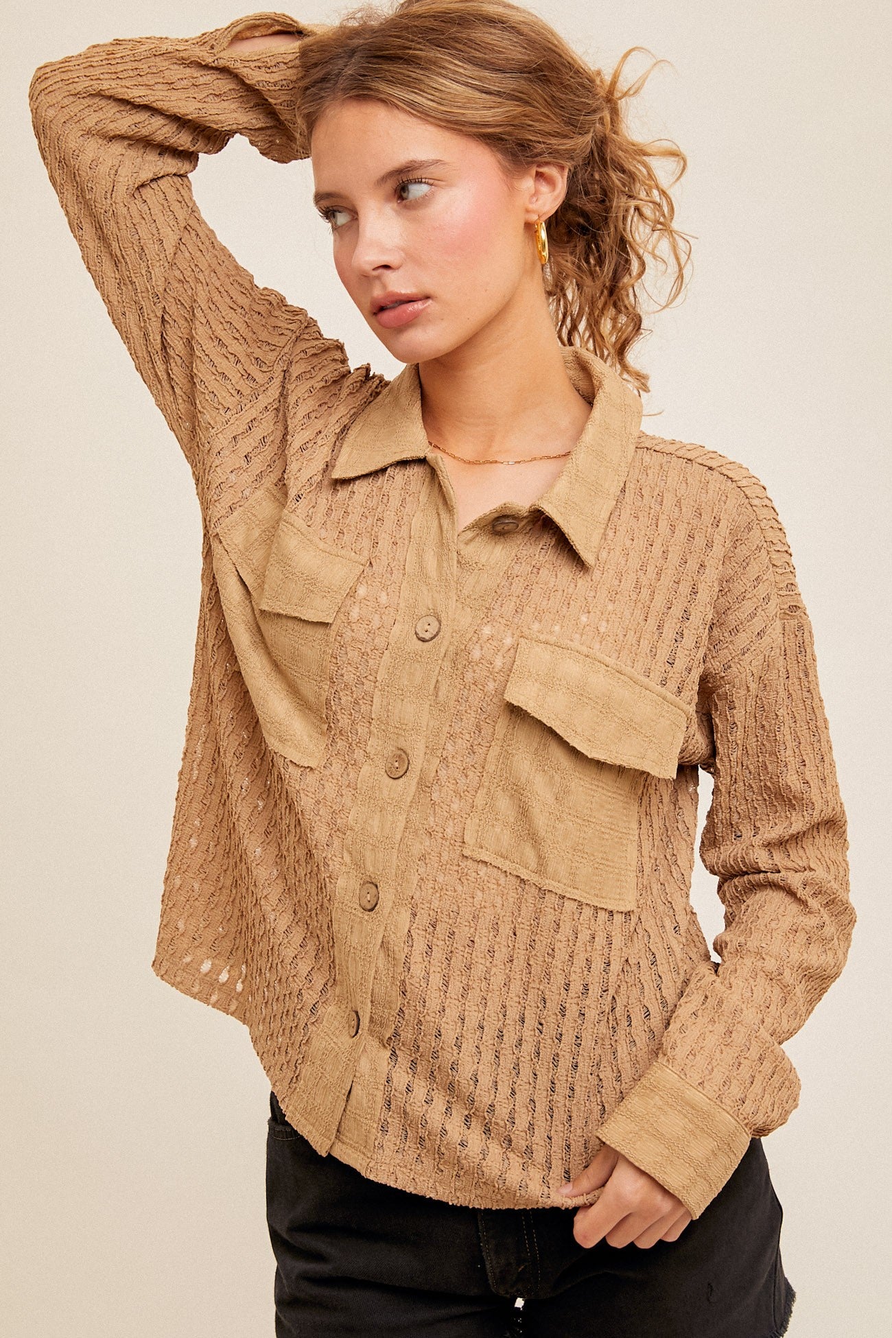 Woman wearing a beige textured shirt with pockets on a beige background
