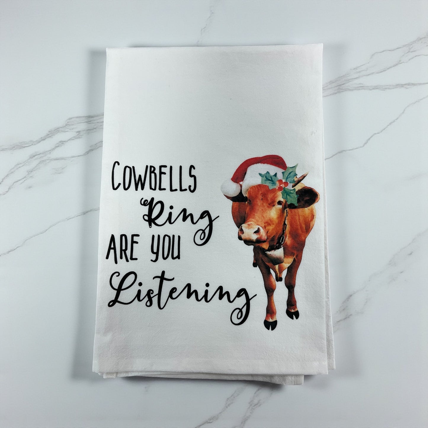 Towel with a cow illustration and text on a marble surface