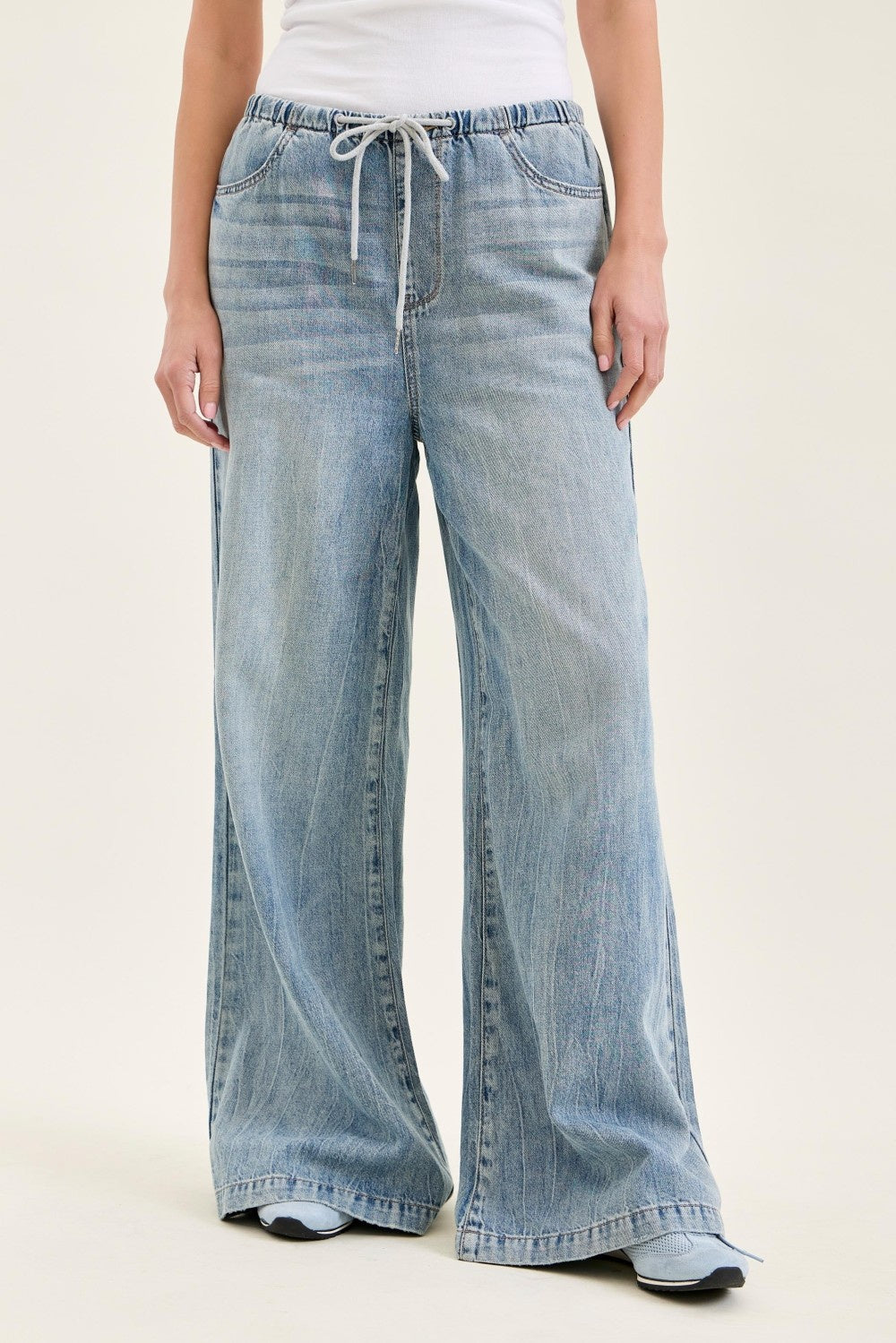 Light blue wide-leg jeans worn by a person on a white background