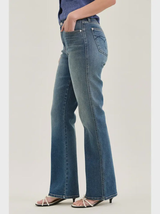 Person wearing blue jeans on a plain background