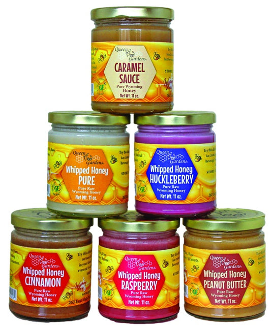 Collection of Queen B's Garden honey and sauce jars in various flavors on a white background