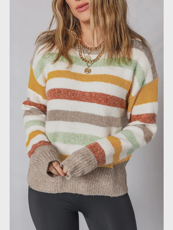Person wearing a colorful striped sweater with a neutral background