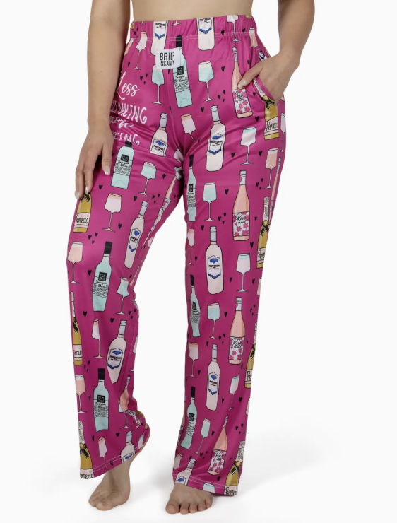 Person wearing pink pajama pants with bottle pattern on a white background