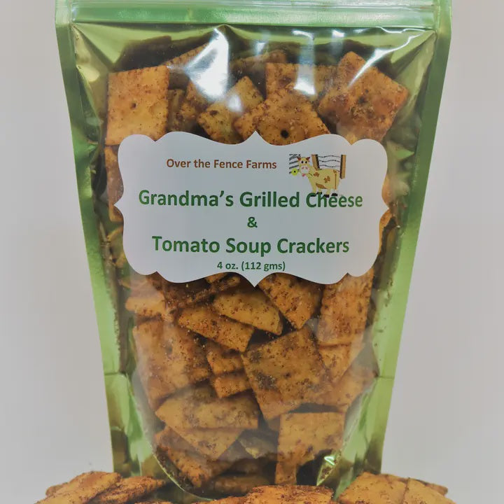 Packaged crackers labeled 'Grandma's Grilled Cheese & Tomato Soup Crackers' from Over the Fence Farms.
